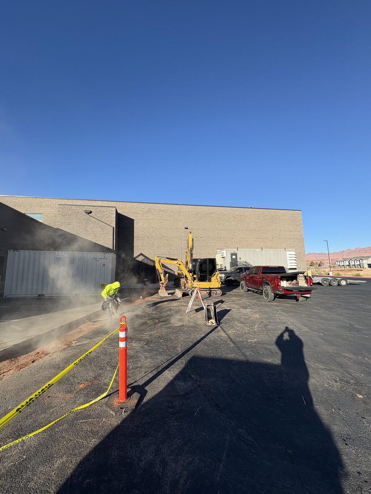 Roxor South crew sawcutting and digging utilities behind a Southern Utah commercial building