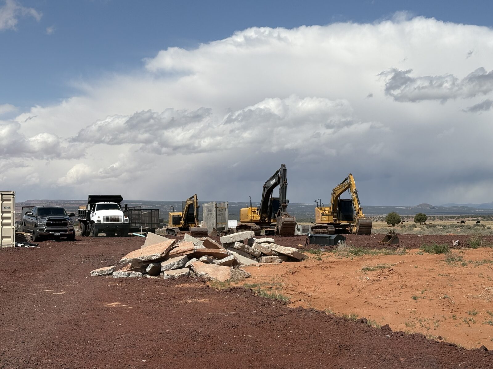 Roxor South dump truck and excavators staged in the Apple Valley yard under wide Southern Utah sky